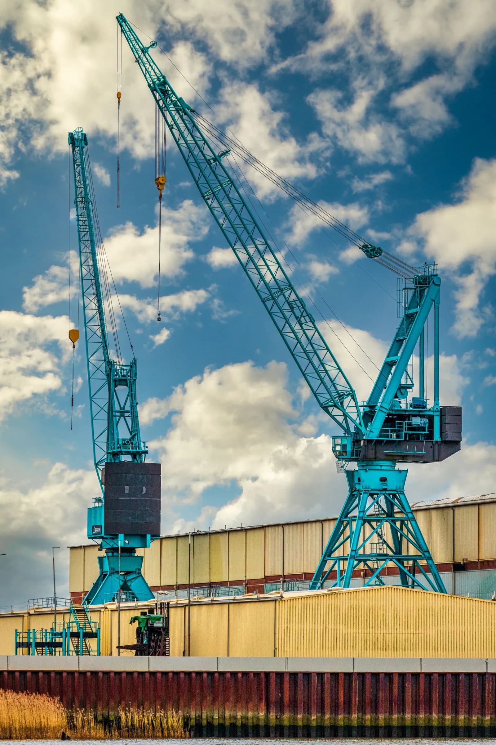 Teal cranes silhouetted at the terminal